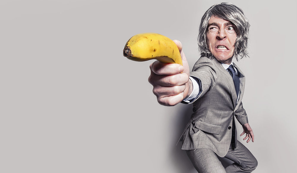 Man using banana like a gun