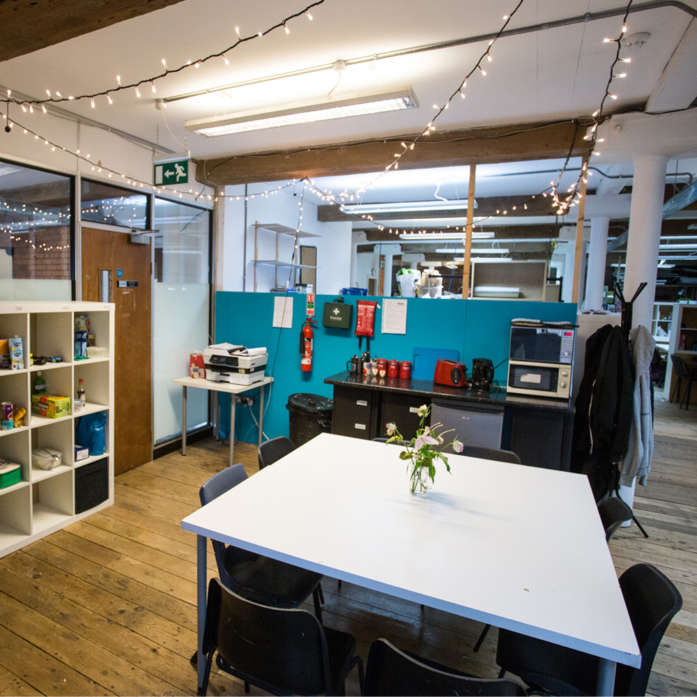 Photo of desk for communal working with shelves to the left