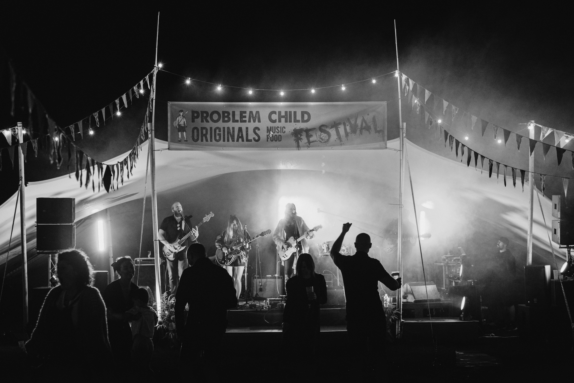 Black and white photograph of the crowd dancing in front of the stage at Problem Child Originals Music Festival